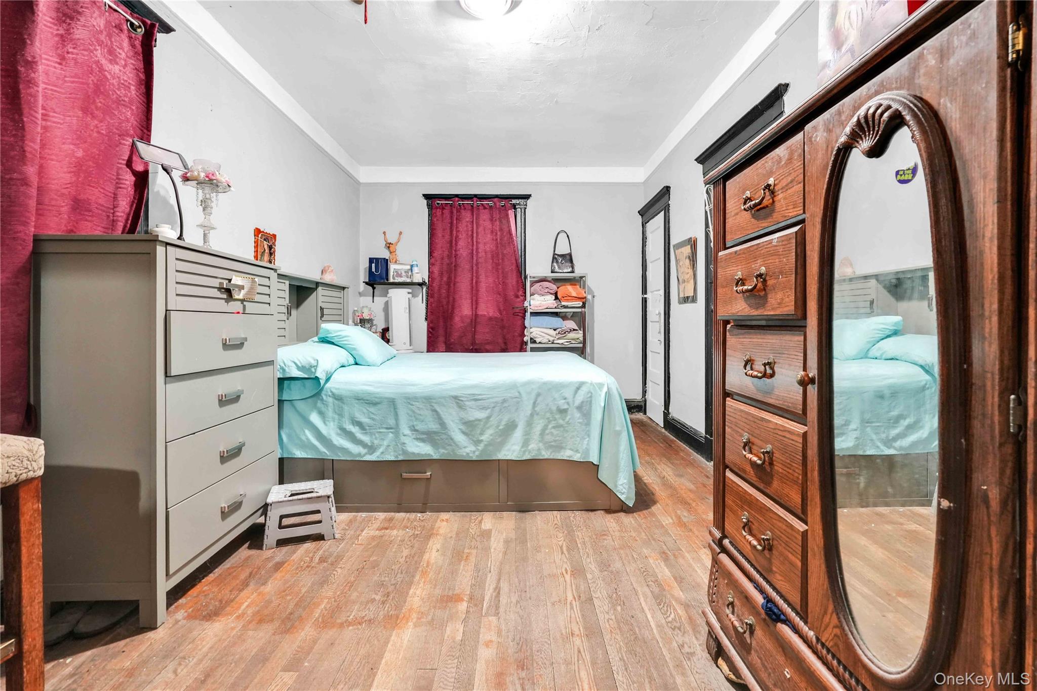 96-12 34th Avenue Queens, NY 11368 - Photo 4 of 35 a bed room with a bed mirror and a dresser