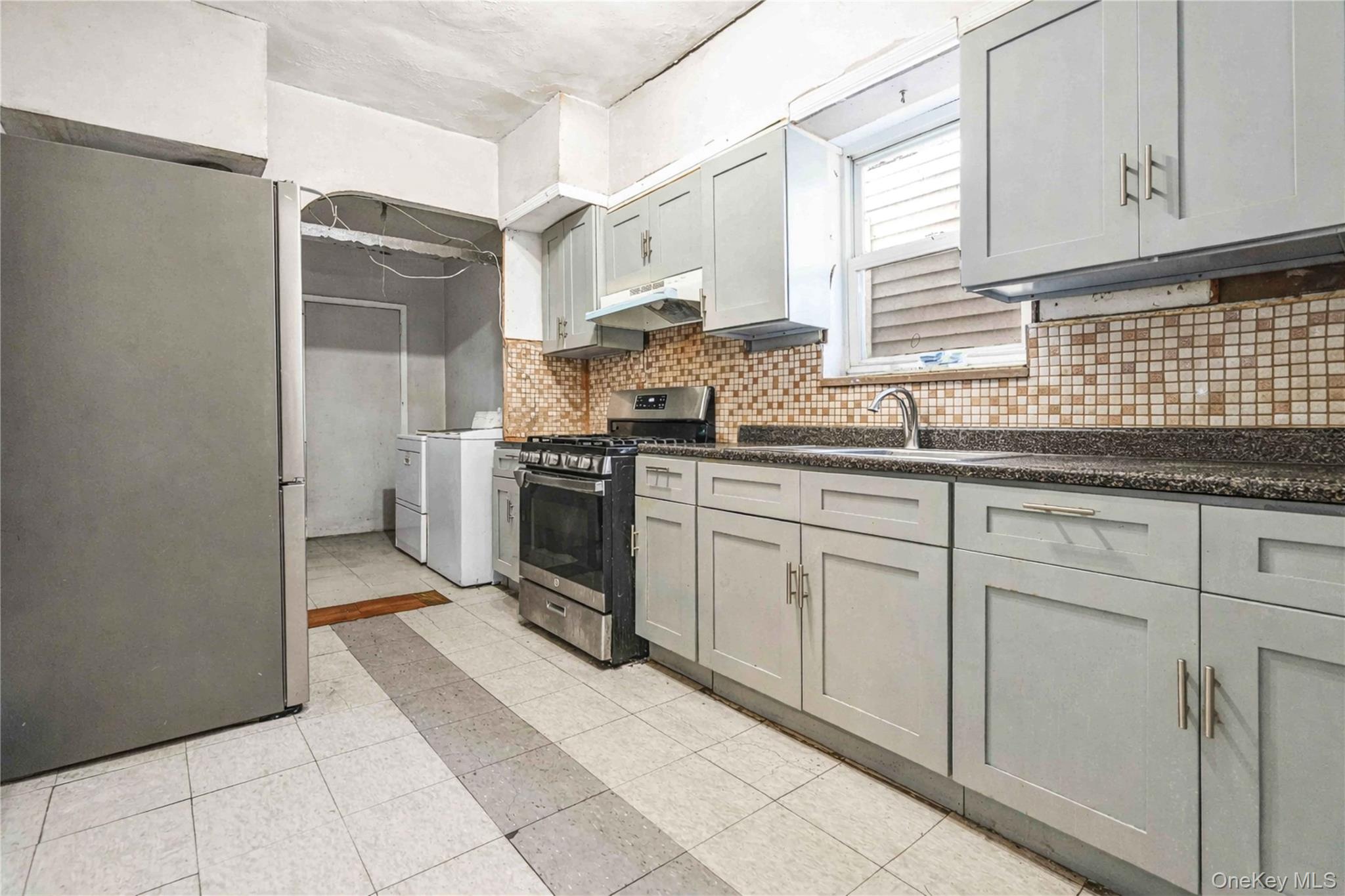 96-12 34th Avenue Queens, NY 11368 - Photo 6 of 35 a kitchen with stainless steel appliances granite countertop a sink stove and cabinets