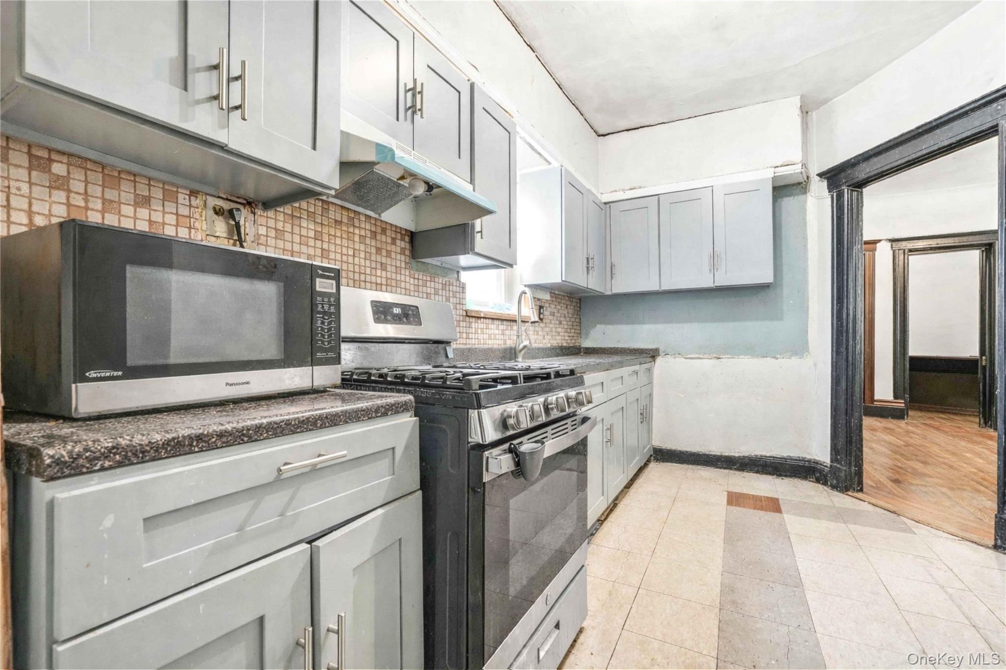 96-12 34th Avenue Queens, NY 11368 - Photo 7 of 35 a kitchen with stainless steel appliances granite countertop a stove a sink and a microwave