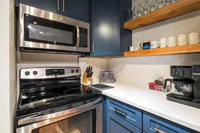 a kitchen with stainless steel appliances a sink stove and microwave