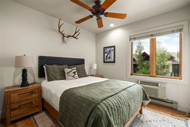 a bedroom with a bed a window and a chandelier