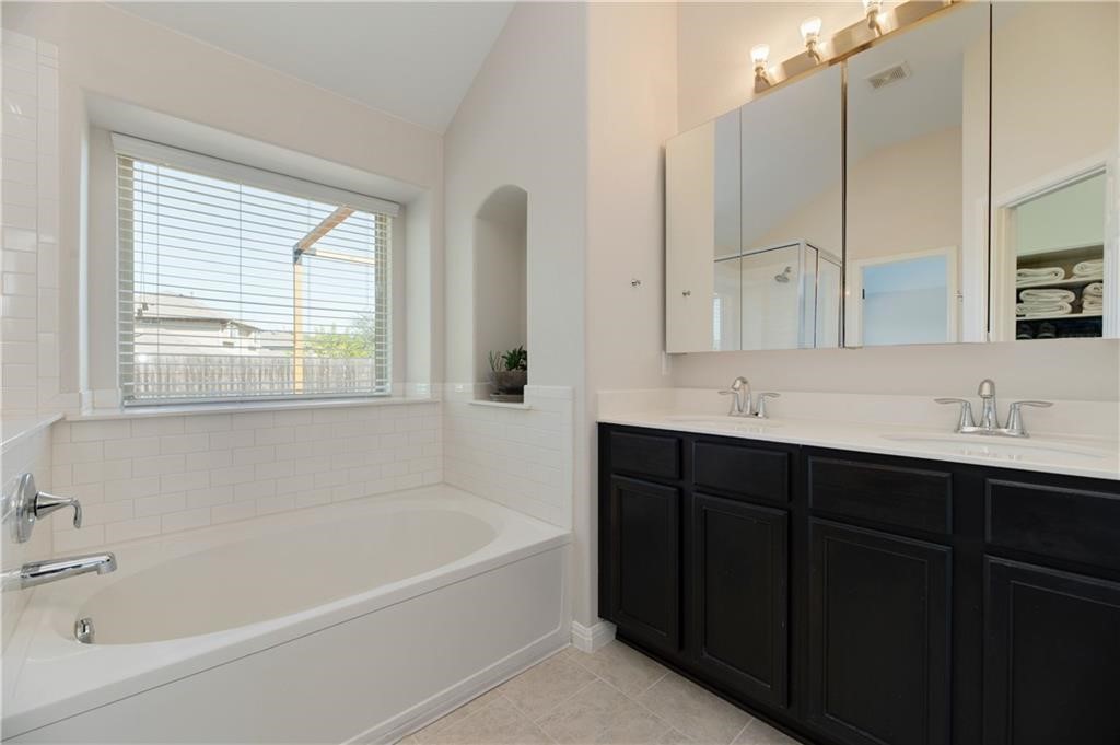 7108 Hester Road Austin, TX 78725 - Photo 8 of 25 a bathroom with a tub sink and mirror