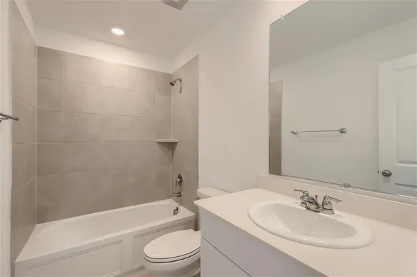 a bathroom with a tub a sink and mirror