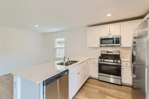 a kitchen with stainless steel appliances granite countertop a refrigerator stove and sink