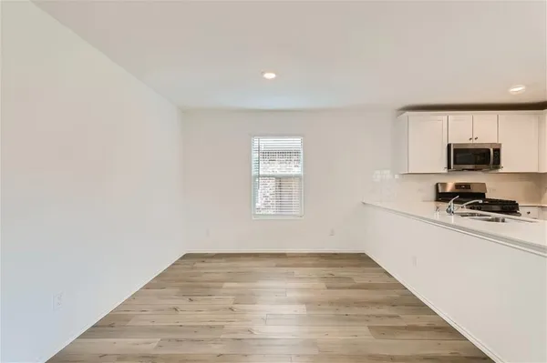a view of a kitchen with wooden floor and a window