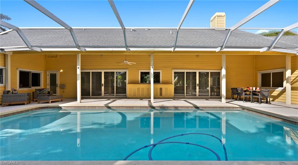 586 Yucca Road Naples, FL 34102 - Photo 20 of 26 Rear view of house with a sunroom, a shingled roof, glass enclosure, and ceiling fan