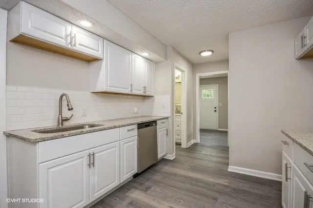 a kitchen with a sink cabinets stainless steel appliances and a window