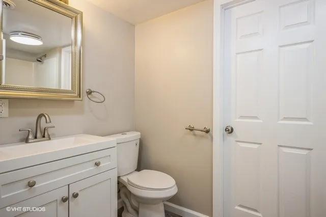 a bathroom with a toilet a sink and mirror