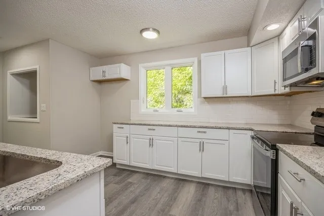 a kitchen that has a sink and a stove in it
