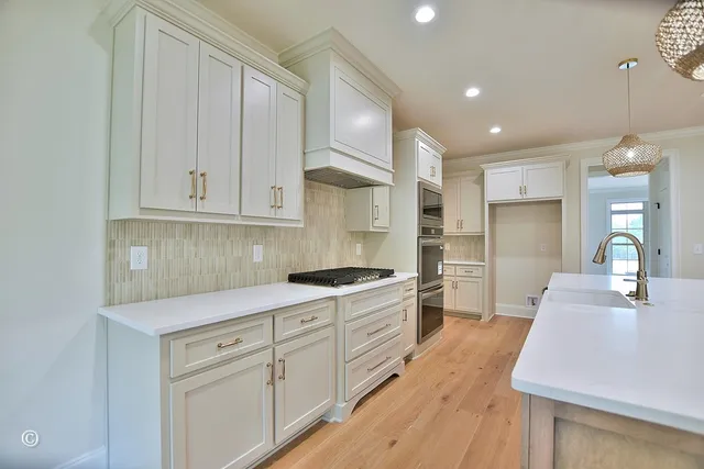 a kitchen with white cabinets and stainless steel appliances