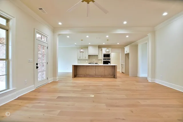 a view of kitchen with kitchen island a sink wooden floor and a refrigerator