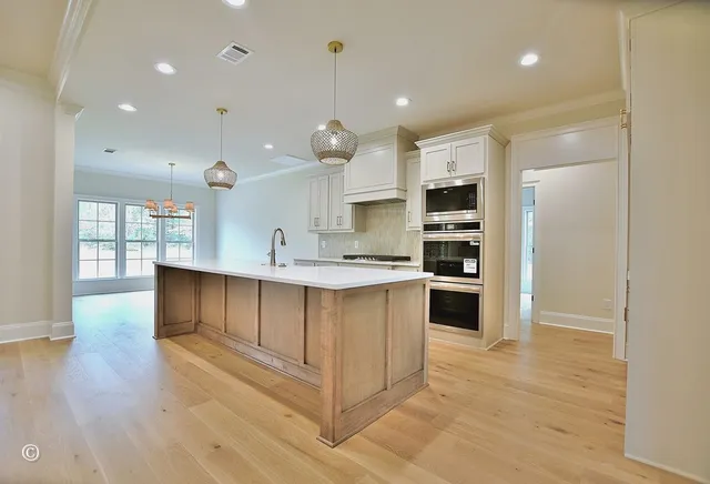 a kitchen with kitchen island a sink stainless steel appliances and cabinets