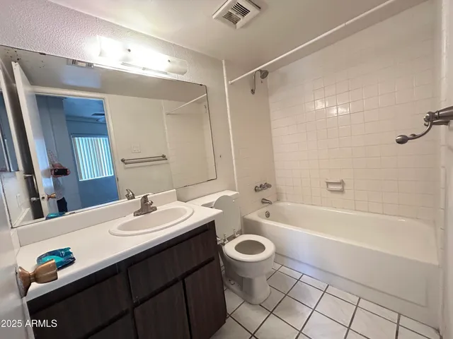 a bathroom with a sink a toilet a mirror a bathtub and shower