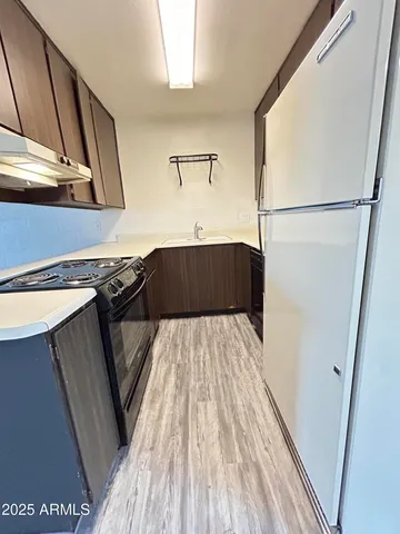 a kitchen with a sink and wooden floor