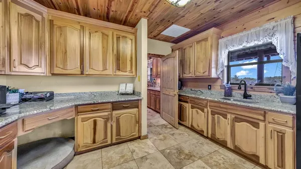 a kitchen with stainless steel appliances a stove a refrigerator a sink a dining table and chairs with wooden floor