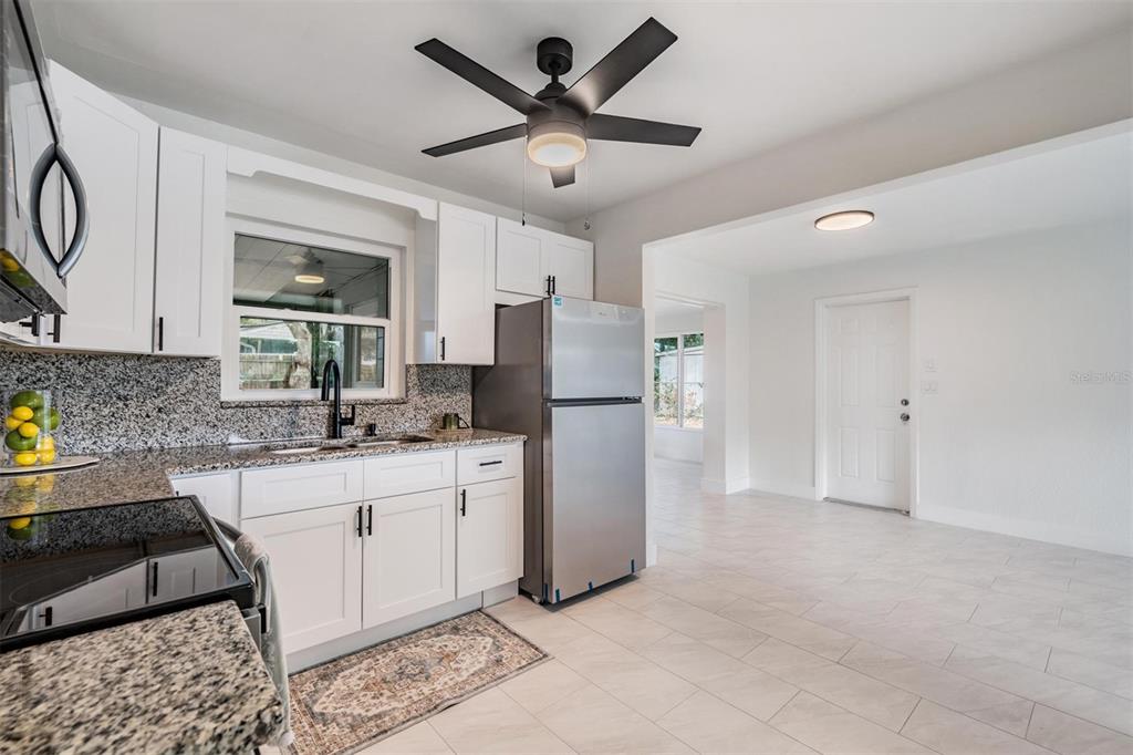 6472 113th Street Seminole, FL 33772 - Photo 15 of 36 a kitchen with white cabinets and stainless steel appliances
