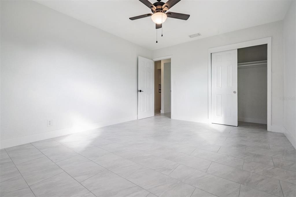 6472 113th Street Seminole, FL 33772 - Photo 27 of 36 an empty room with a ceiling fan and carpet