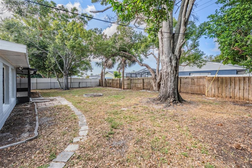 6472 113th Street Seminole, FL 33772 - Photo 32 of 36 a backyard of a house with large trees and wooden fence