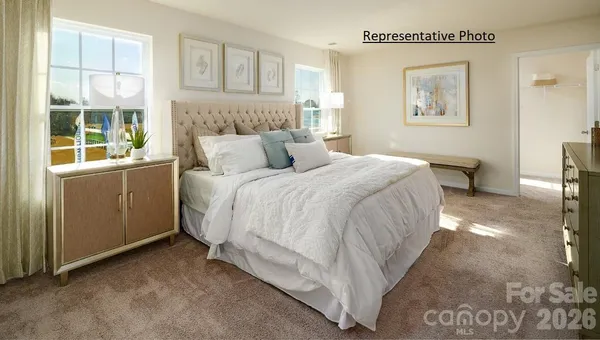a large bed sitting in a bedroom next to a window