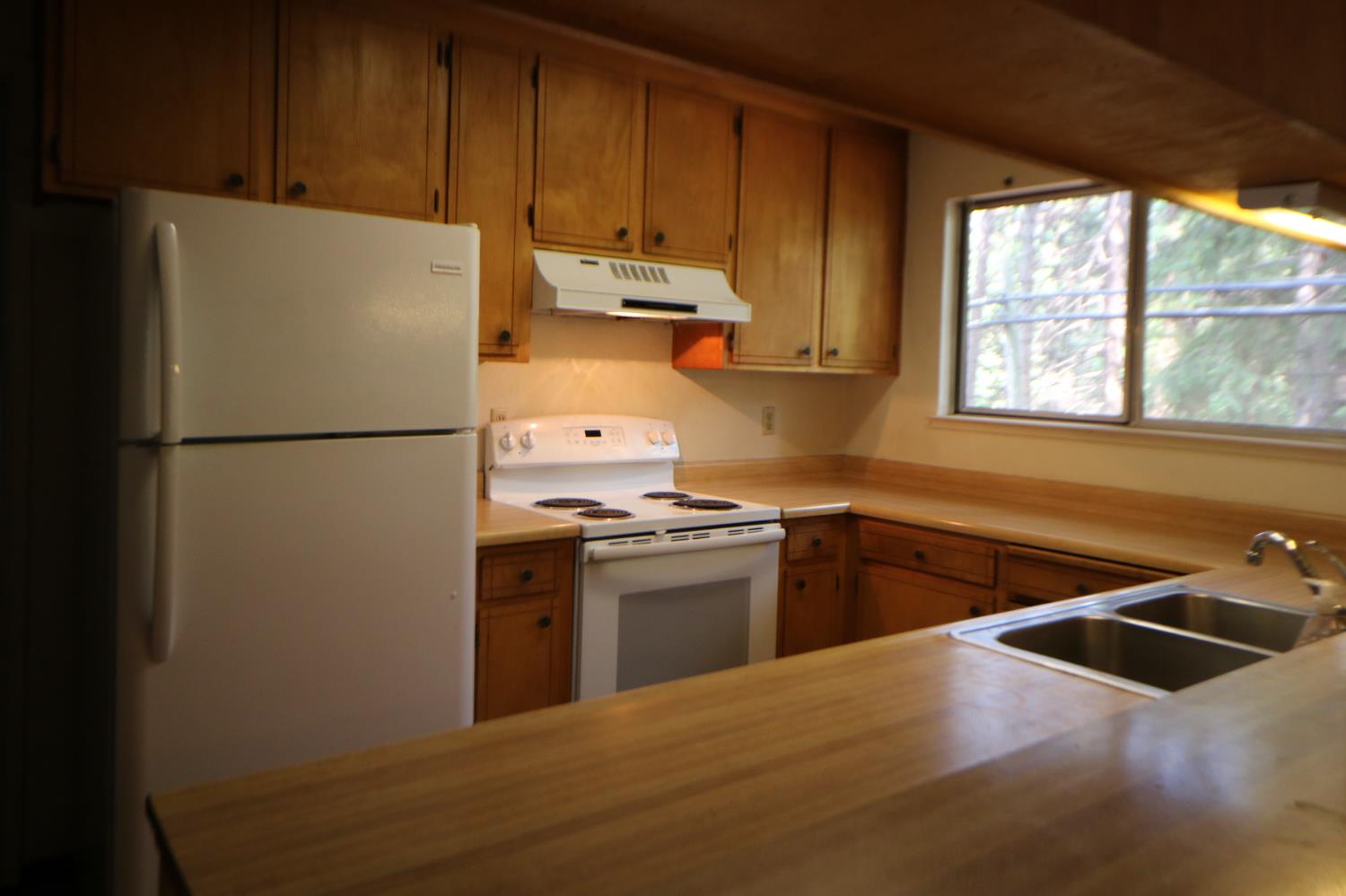 1536 Meadowview Road Arnold, CA 95223 - Photo 7 of 22 a kitchen with stainless steel appliances granite countertop a refrigerator a sink a stove and a refrigerator