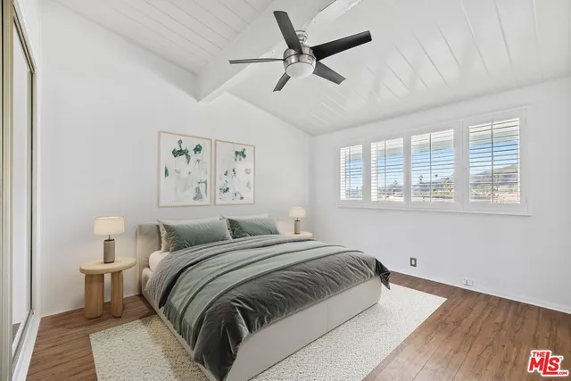 a bedroom with a bed and a painting on the wall