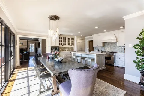 a kitchen with a dining table chairs stainless steel appliances and cabinets