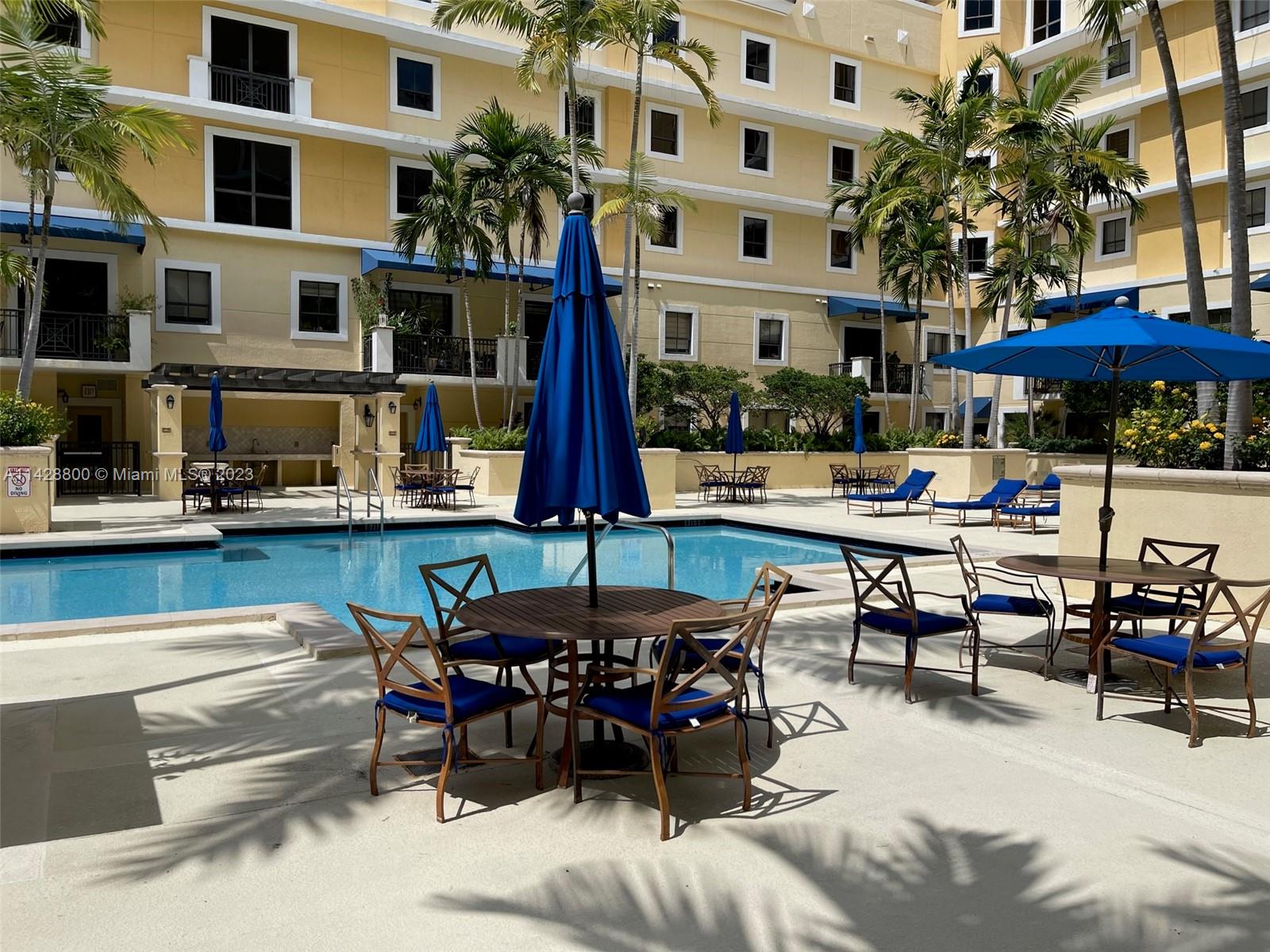 Se Colonnade at Dadeland Condominiums Miami, FL 33143 - Photo 27 of 32 a view of a patio with dining table and chairs under an umbrella with a fire pit