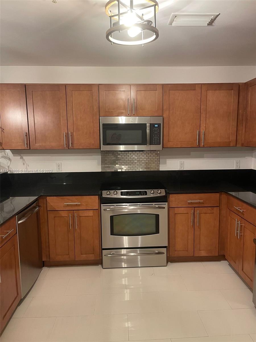 Se Colonnade at Dadeland Condominiums Miami, FL 33143 - Photo 8 of 32 a kitchen with granite countertop a stove top oven a sink and cabinets