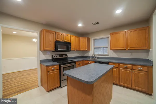 a kitchen with a sink a microwave a stove and cabinets