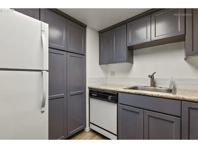 a kitchen with kitchen island a counter top space cabinets and stainless steel appliances