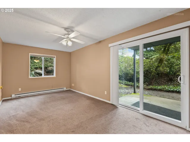an empty room with windows and ceiling fan