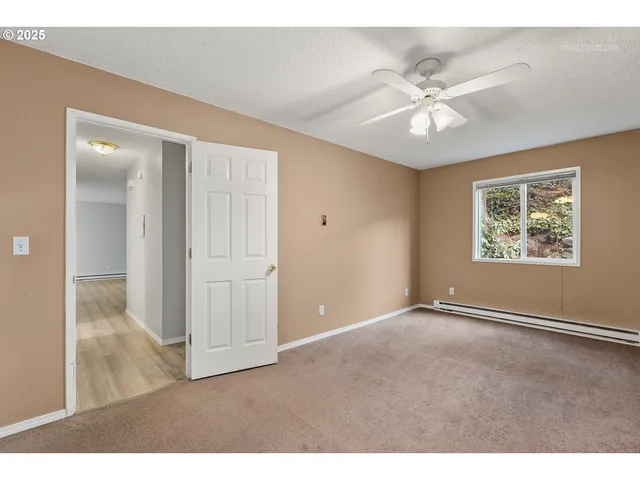 an empty room with fan and windows