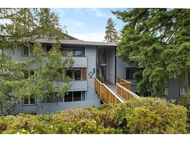 a view of a house with brick walls and a yard with plants