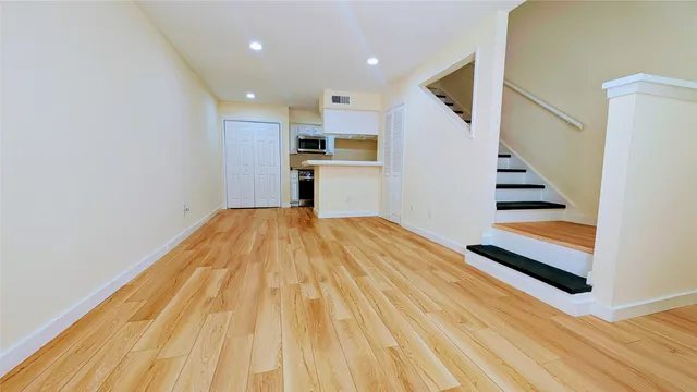 a view of a kitchen with wooden floor and stairs