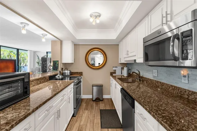 a kitchen with stainless steel appliances granite countertop a stove a sink and a microwave