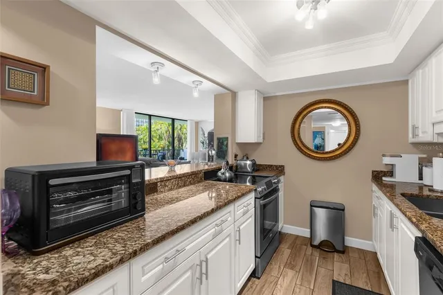 a kitchen with kitchen island granite countertop a sink a stove and a wooden cabinets