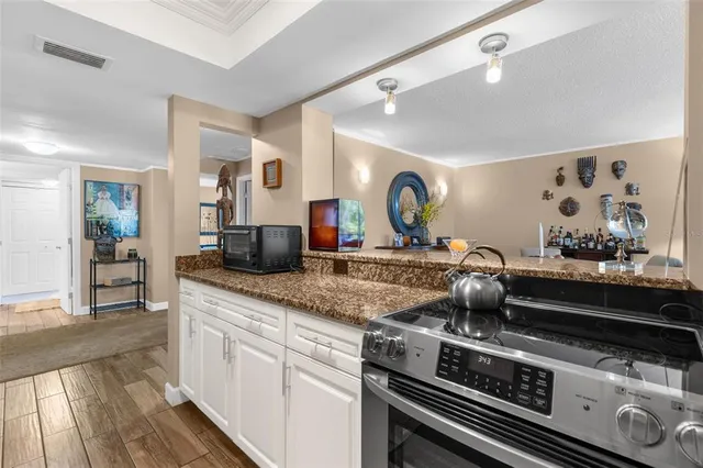 a kitchen with stainless steel appliances granite countertop a refrigerator a stove and a sink