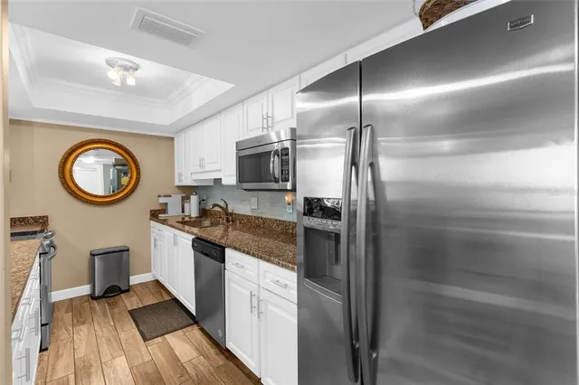 a large kitchen with stainless steel appliances granite countertop a lot of cabinets a stove and a sink