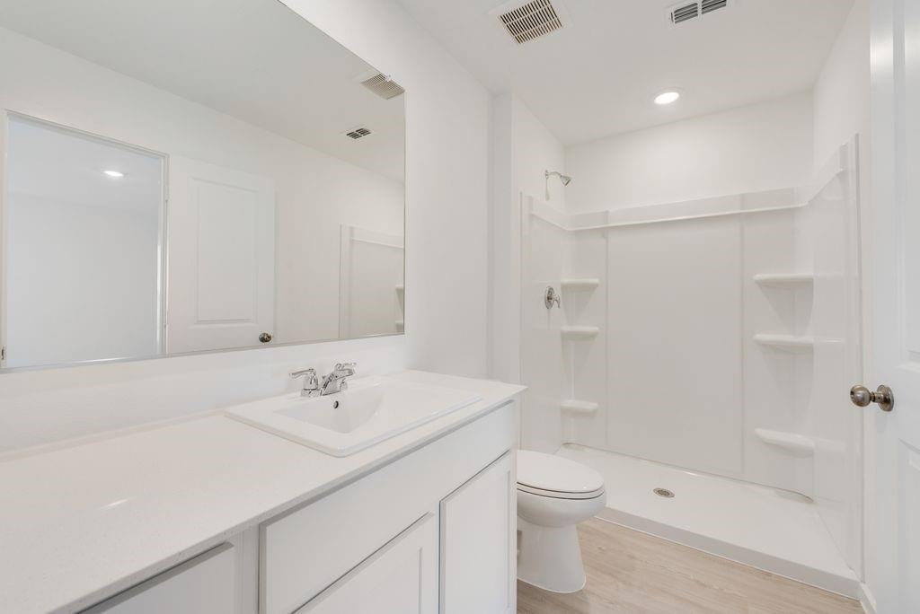 1225 Finch Drive Cleburne, TX 76031 - Photo 16 of 16 Bathroom featuring vanity, a stall shower, light wood-style flooring, and recessed lighting