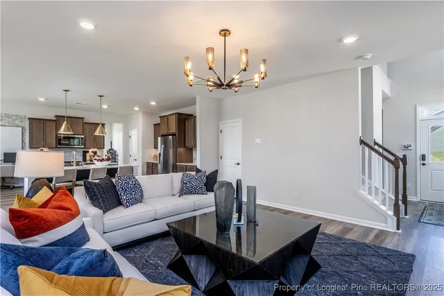 a living room with furniture a table and kitchen view