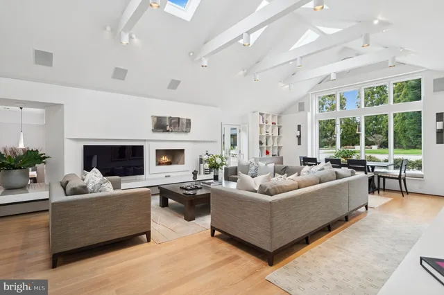 a living room with furniture a flat screen tv and kitchen view