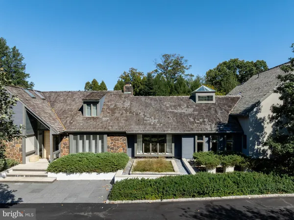 a front view of a house with a yard and potted plants