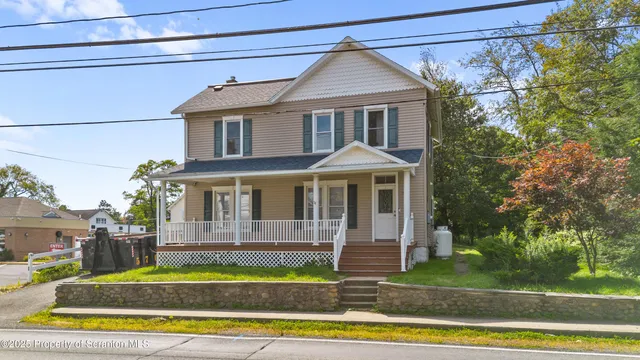 a front view of a house with a yard table and chairs