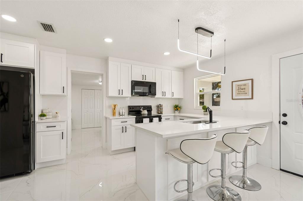 7097 Delta Way Clearwater, FL 33764 - Photo 22 of 71 a kitchen with stainless steel appliances kitchen island granite countertop a refrigerator and microwave
