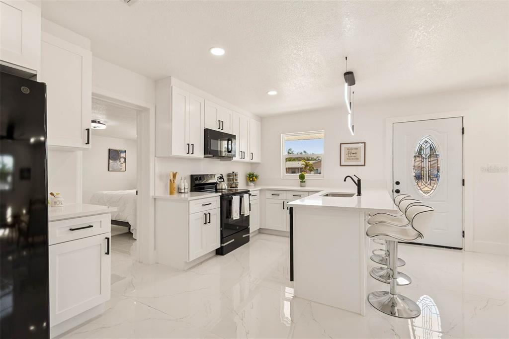 7097 Delta Way Clearwater, FL 33764 - Photo 23 of 71 a kitchen with white cabinets and stainless steel appliances