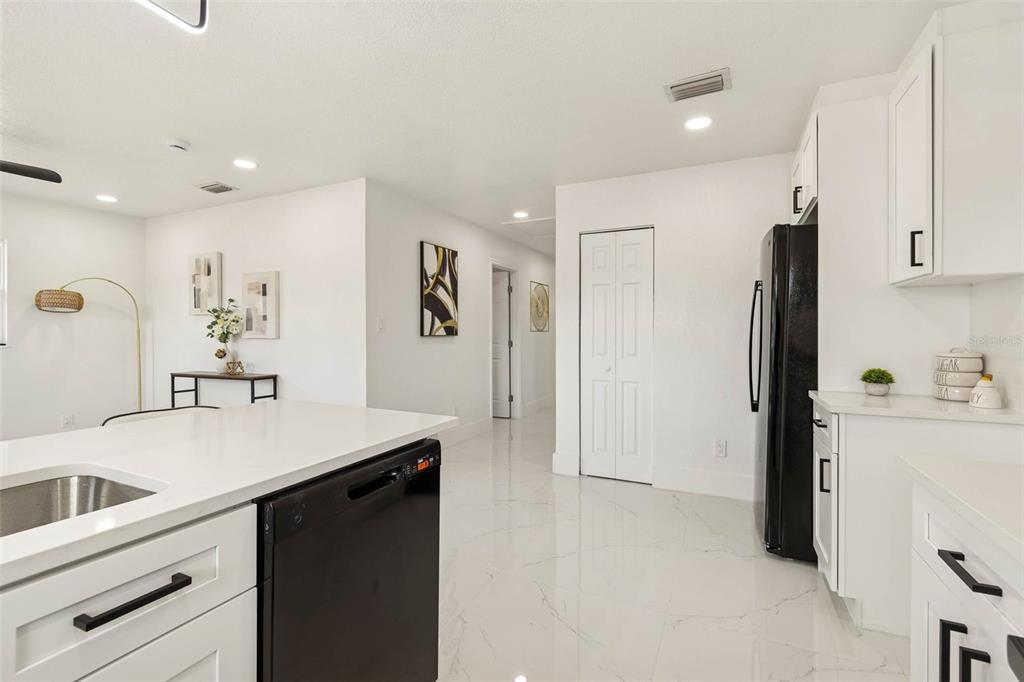7097 Delta Way Clearwater, FL 33764 - Photo 27 of 71 a kitchen with a sink a refrigerator and cabinets