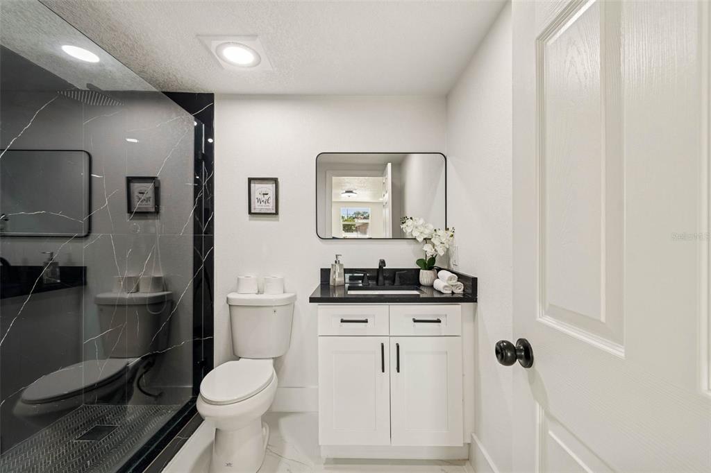 7097 Delta Way Clearwater, FL 33764 - Photo 37 of 71 a bathroom with a granite countertop toilet sink and mirror