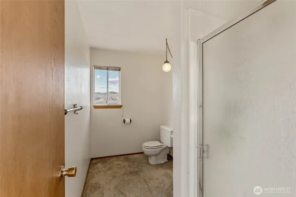 a bathroom with a toilet and a shower