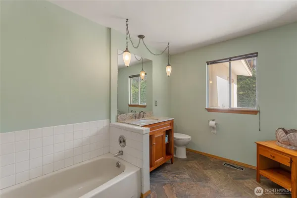 a bathroom with a bathtub sink vanity and toilet