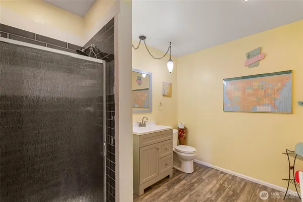 a bathroom with a granite countertop sink a toilet and shower